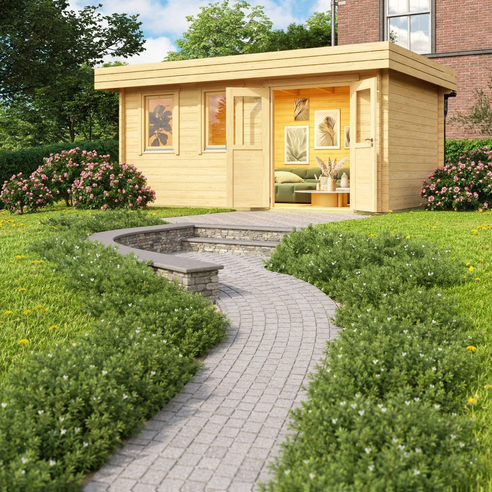 A vibrant garden scene showcases the GardenHouse24 USA Miriam 44B Classic Garden Room with open double doors revealing a cozy interior filled with framed artwork, greenery, and a soft sofa