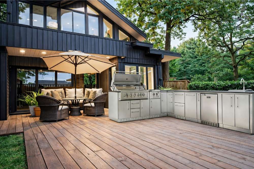 Modern deck with Sunstone Rancher L-Shaped 8′11″ × 11′ Outdoor Kitchen Package, grill, sink, and cozy seating
