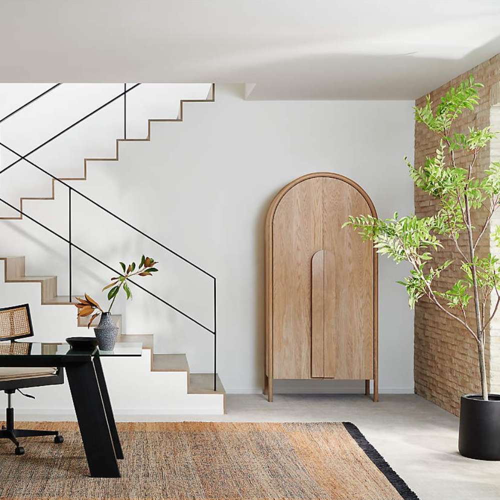 Modern home office featuring Crate & Barrel Annie 38" Natural Storage Cabinet beneath a staircase with clean architectural lines