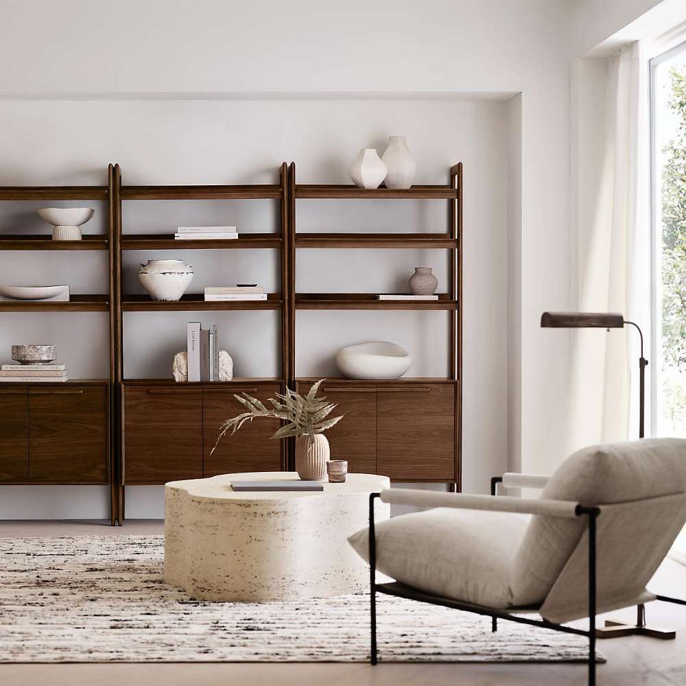 Modern living room featuring multiple Crate & Barrel Tate 36" Walnut Wood 3-Shelf Storage Bookcase Cabinet units styled with decorative objects and books