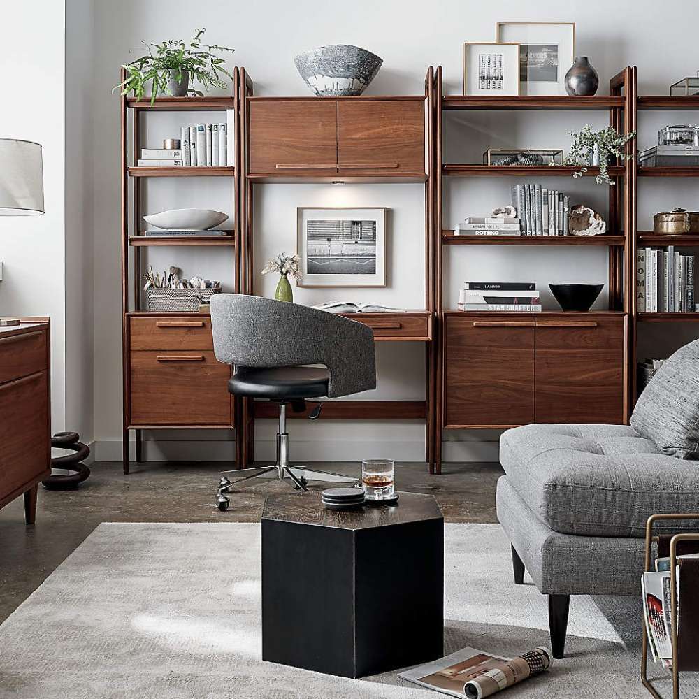 Modern workspace furnished with multiple walnut storage pieces, including the Crate & Barrel Tate Walnut Bookcase File Cabinet, arranged around a compact desk