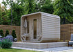 Modern wooden Sawmill Structures Box Sauna with curved edges and a glass door, set on a raised platform in a garden