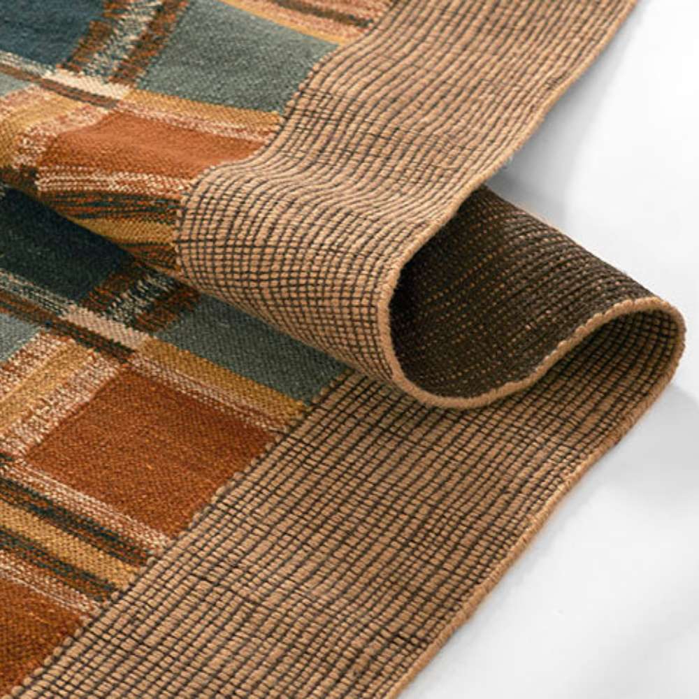 Momeni Adobe Indoor Rug - ADO-3 Blue is gently rolled displaying both the textured border and patterned surface