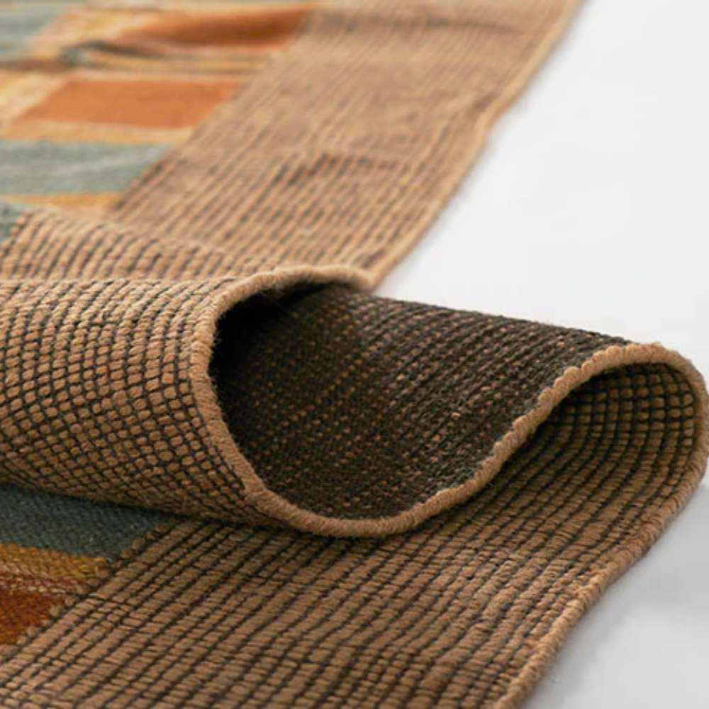 Momeni Adobe Indoor Rug - ADO-3 Blue shows its flexibility as it is partially folded revealing a sturdy backing