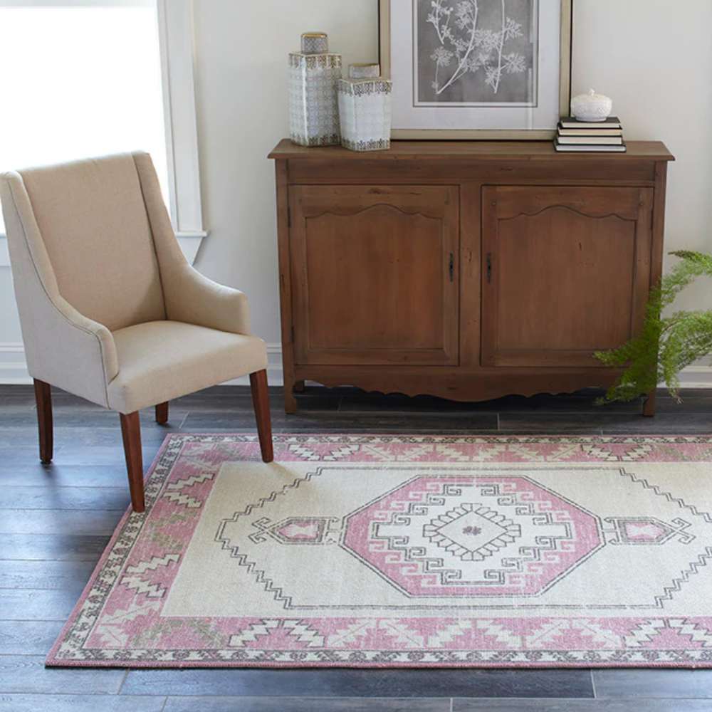 Momeni Anatolia Indoor Rug - ANA-2 Pink adds a cozy, vintage charm to a living room with wooden furniture and neutral seating