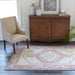 Momeni Anatolia Indoor Rug - ANA-2 Pink adds a cozy, vintage charm to a living room with wooden furniture and neutral seating