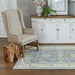 Momeni Anatolia Indoor Rug - ANA-7 Light Blue adds elegance to a cozy room with a beige armchair, wooden stool, and white cabinet