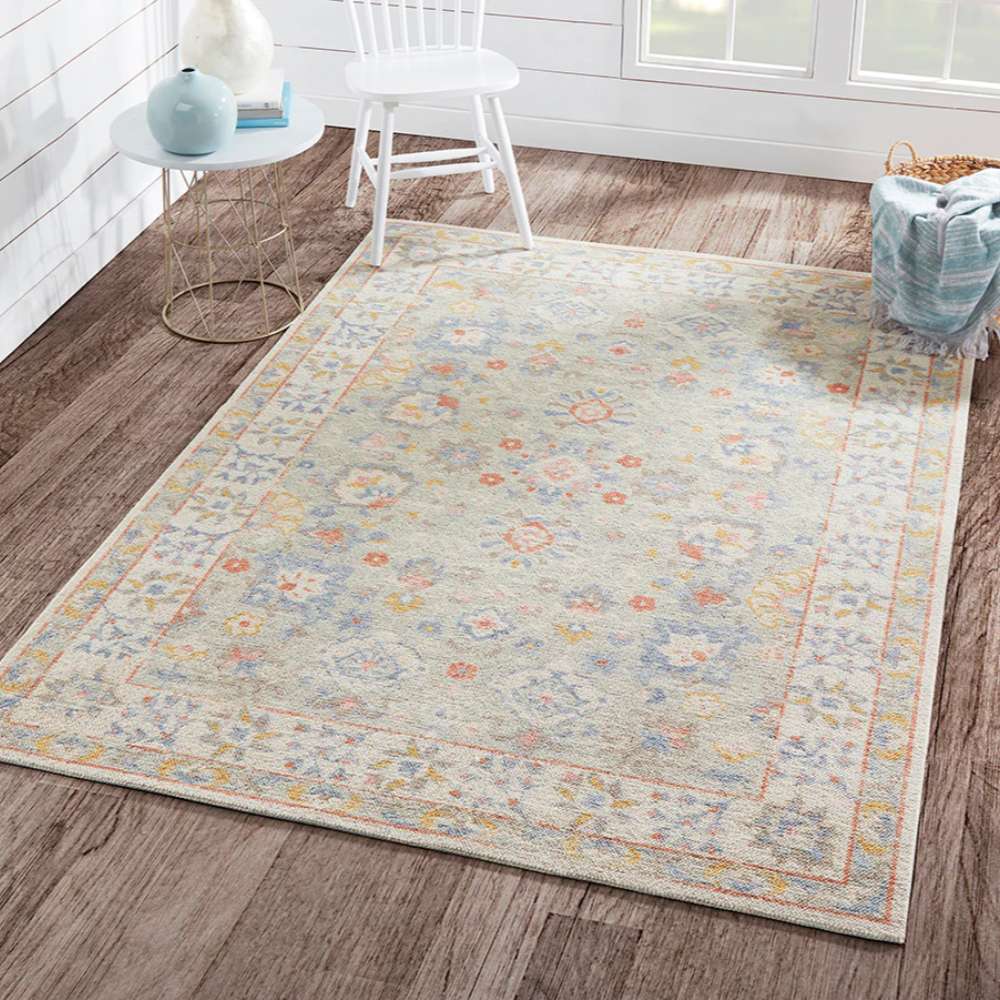 Momeni Anatolia Indoor Rug - ANA-8 Light Blue displayed in a bright sunroom adding a soft and colorful foundation beneath light furniture and natural décor