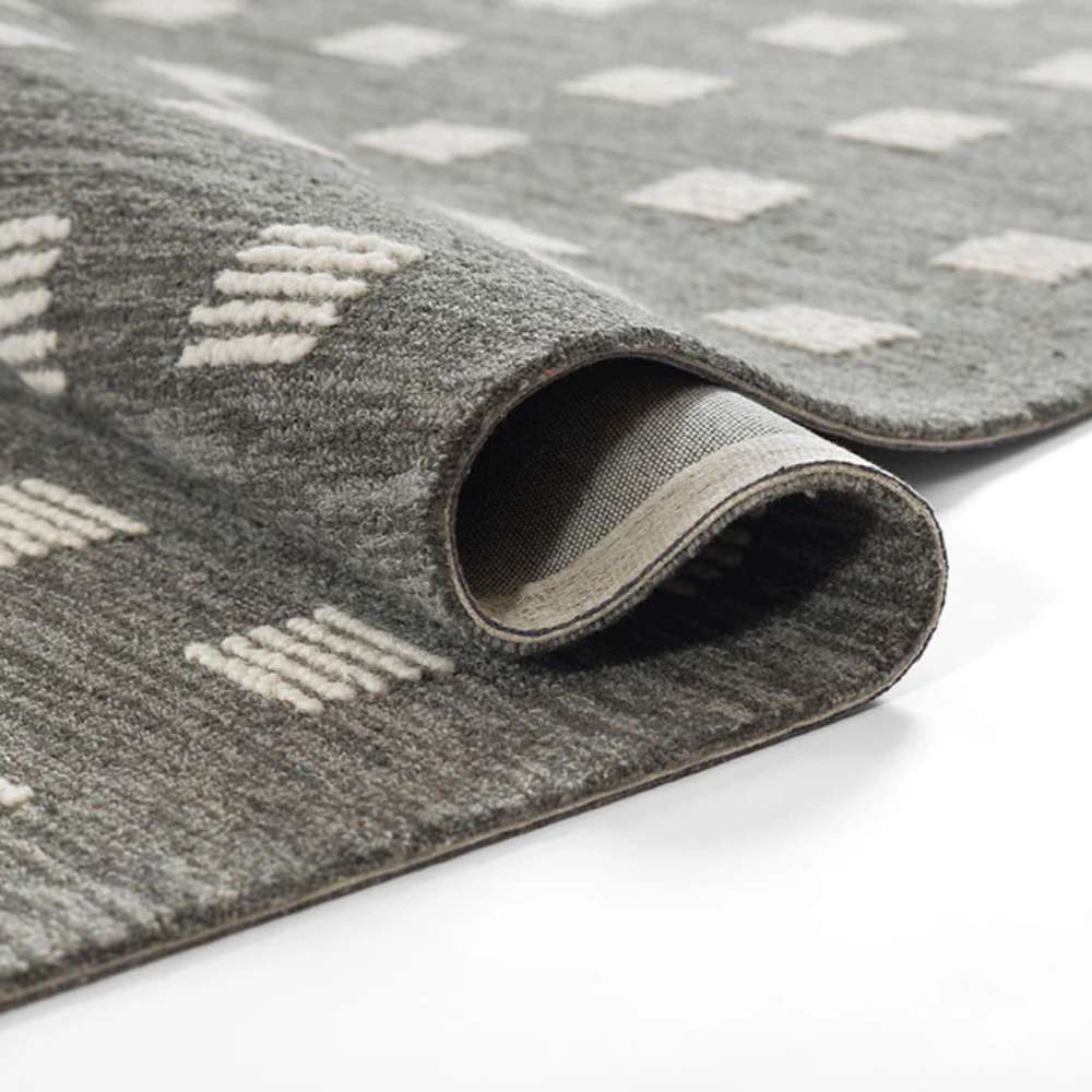 Momeni Archer Indoor Rug - ARC-1 Charcoal rolls slightly to show flexibility while keeping its geometric square design intact