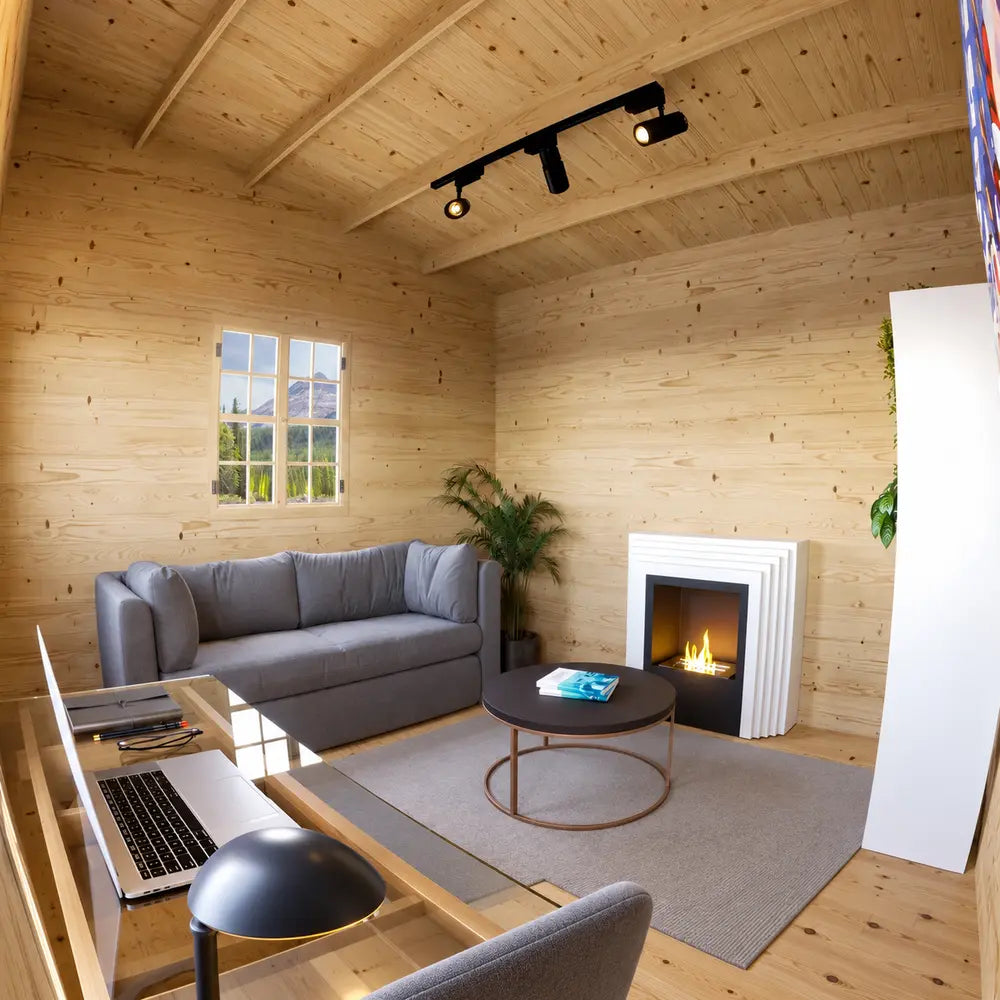 Multi Cube Versa 100 lounge with a gray sofa, modern white fireplace, round coffee table, window, desk, and pine-paneled walls.