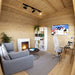 Warm pine interior of the Multi Cube Versa 100 with a gray sofa, modern fireplace, round coffee table, shelving, television, and compact workspace.