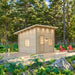 Single-room Multi Cube Versa 100 cabin with a slanted roof on a wooden deck amid tall forest trees and landscaped greenery.