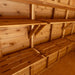 Multiple tiers of Outdoor Living Today 8ft Western Red Cedar Shed Shelves (Set of 3) are mounted along a shed wall