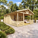 Nepean 44A wooden garden room with a covered gabled porch, decorative railing and lounge chairs in a lush landscaped backyard.