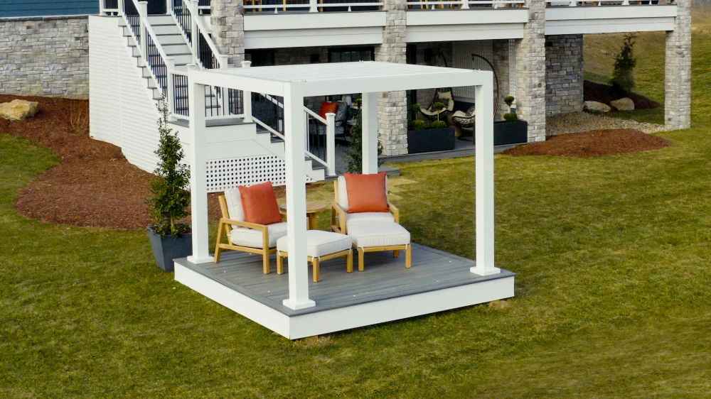 Nestled among trees, a red Structureworks Element Trex Pergola covers a stylish deck furnished with cozy seating and rustic charm