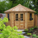 Nestled among lush greenery, the Outdoor Living Today 9×9 Penthouse Garden Shed adds charm to a landscaped backyard garden