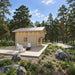Northwood Grand DD wooden cabin in a peaceful pine clearing with a metal roof, broad deck, white Adirondack chairs and black firepit.
