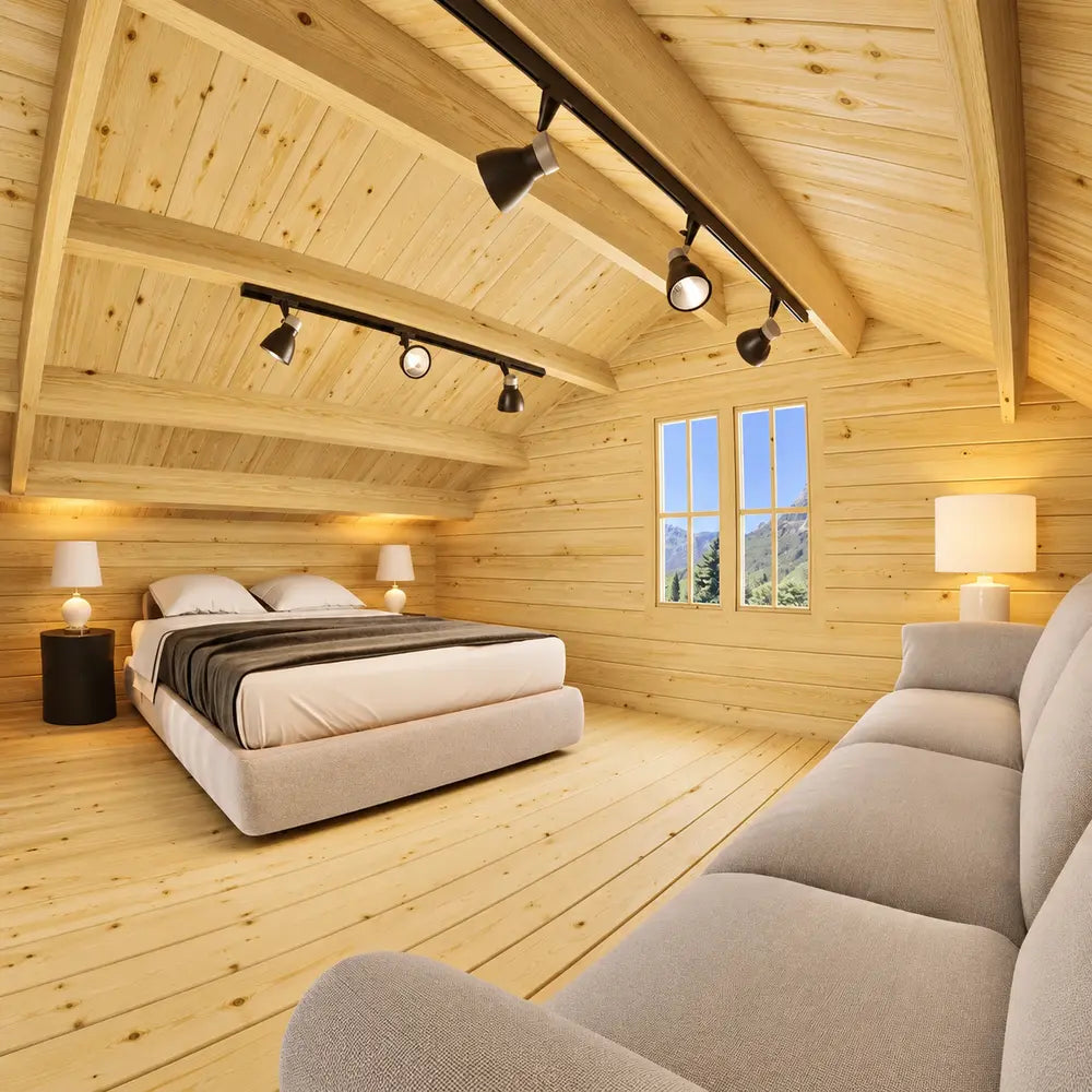Northwood Grand loft bedroom with a plush double bed, gray blanket, light-colored couch, modern track lighting and a sloped pine ceiling.