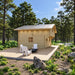 Side view of the Northwood Grand wooden cabin with a metal roof, spacious deck, three white Adirondack chairs and a black firepit.