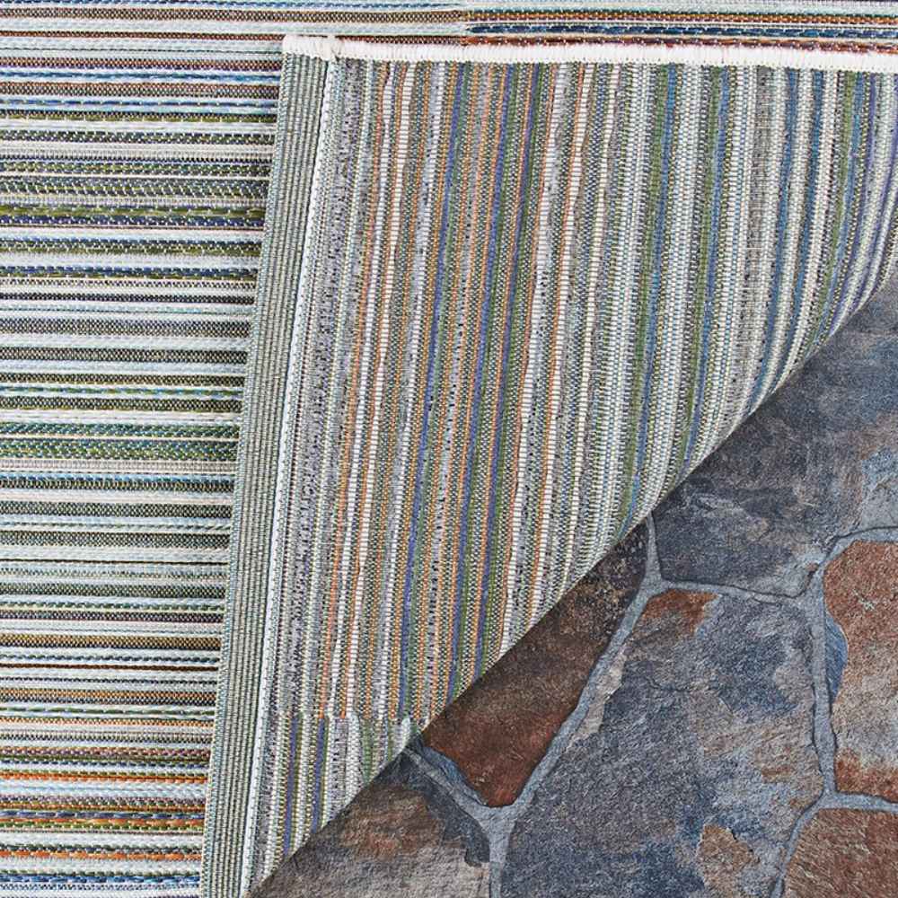 One corner of the Couristan Cape Indoor/Outdoor Rug - Shoreham/Ivory-Multi is flipped to reveal the backside’s neat finish and consistent pattern