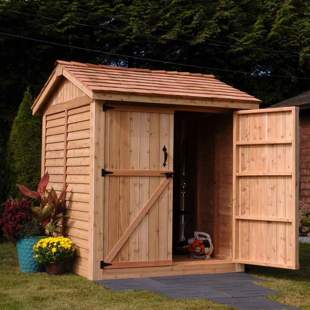 One door of the Outdoor Living Today Maximizer 6×6 Wooden Shed is open, revealing gardening equipment stored neatly inside