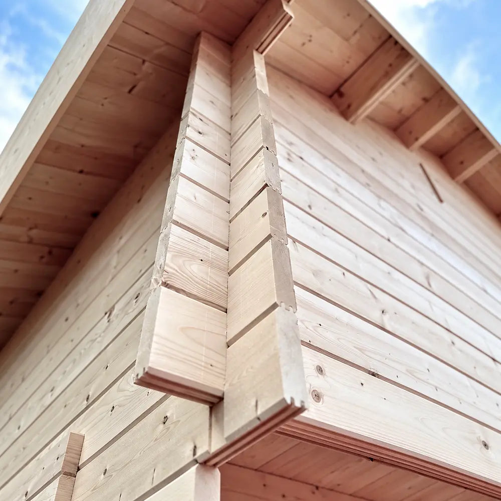 Close-up of the Ontario Grand Loft 107 SD’s interlocking timber corner notches and pale log-wall construction beneath the roof eaves.