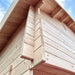 Close-up of the Ontario Grand Loft 107 SD’s interlocking timber corner notches and pale log-wall construction beneath the roof eaves.
