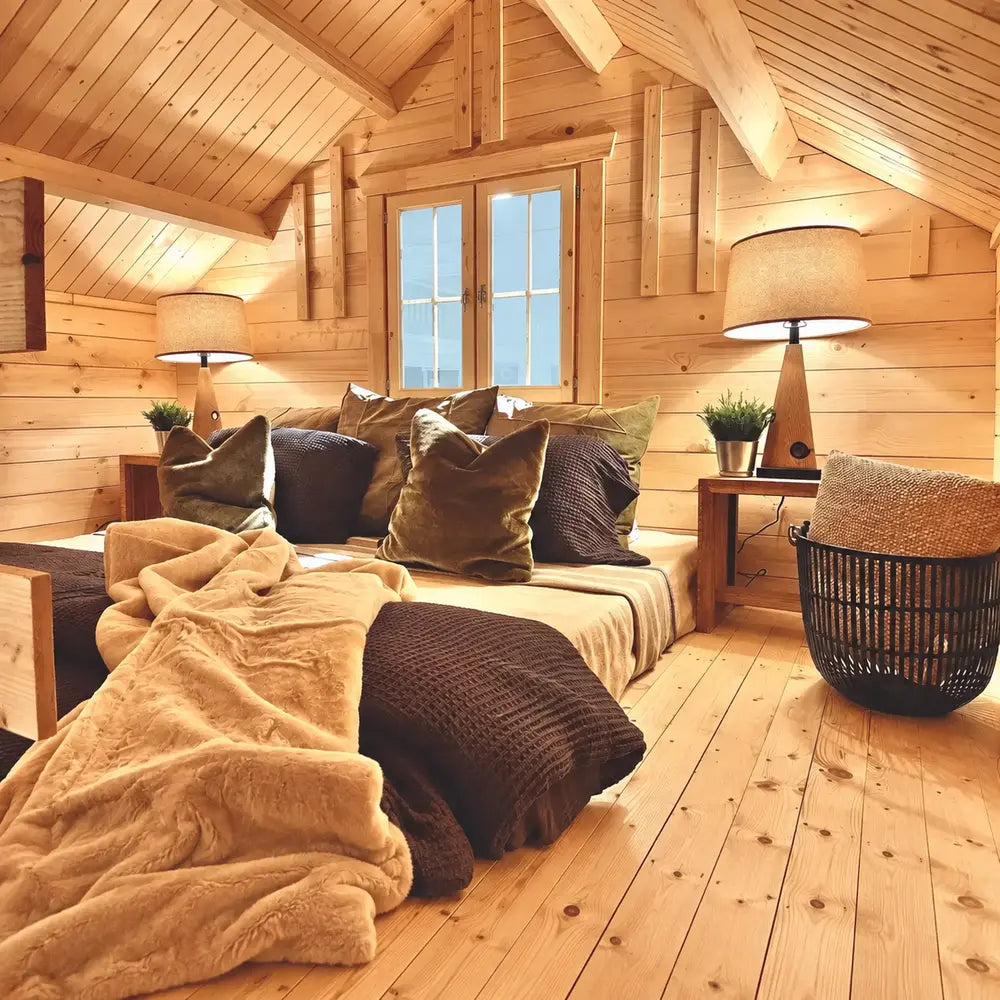 Cozy Ontario Grand Loft 107 SD lounge nook with layered pillows, warm table lamps, a central window, and natural pine walls.