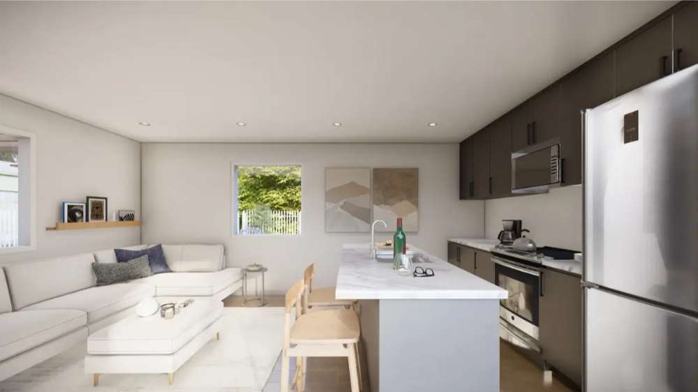 Open-concept kitchen and living area features neutral tones and modern furniture inside Sawmill Structures The Banff Garden Suites