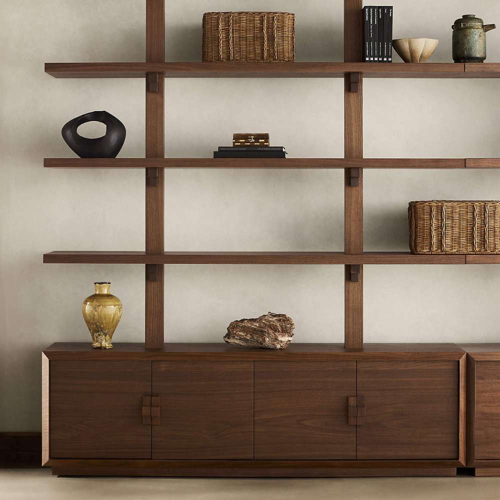 Open shelves on Crate & Barrel Steppe 68" Walnut Storage Bookcase Room Divider display woven baskets, books, pottery, and decorative accents