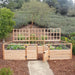 Outdoor Living Today 12ft Raised Garden Bed Climbing Support encloses a garden bed with an open gate and visible irrigation lines, bordered by wooden lattice panels