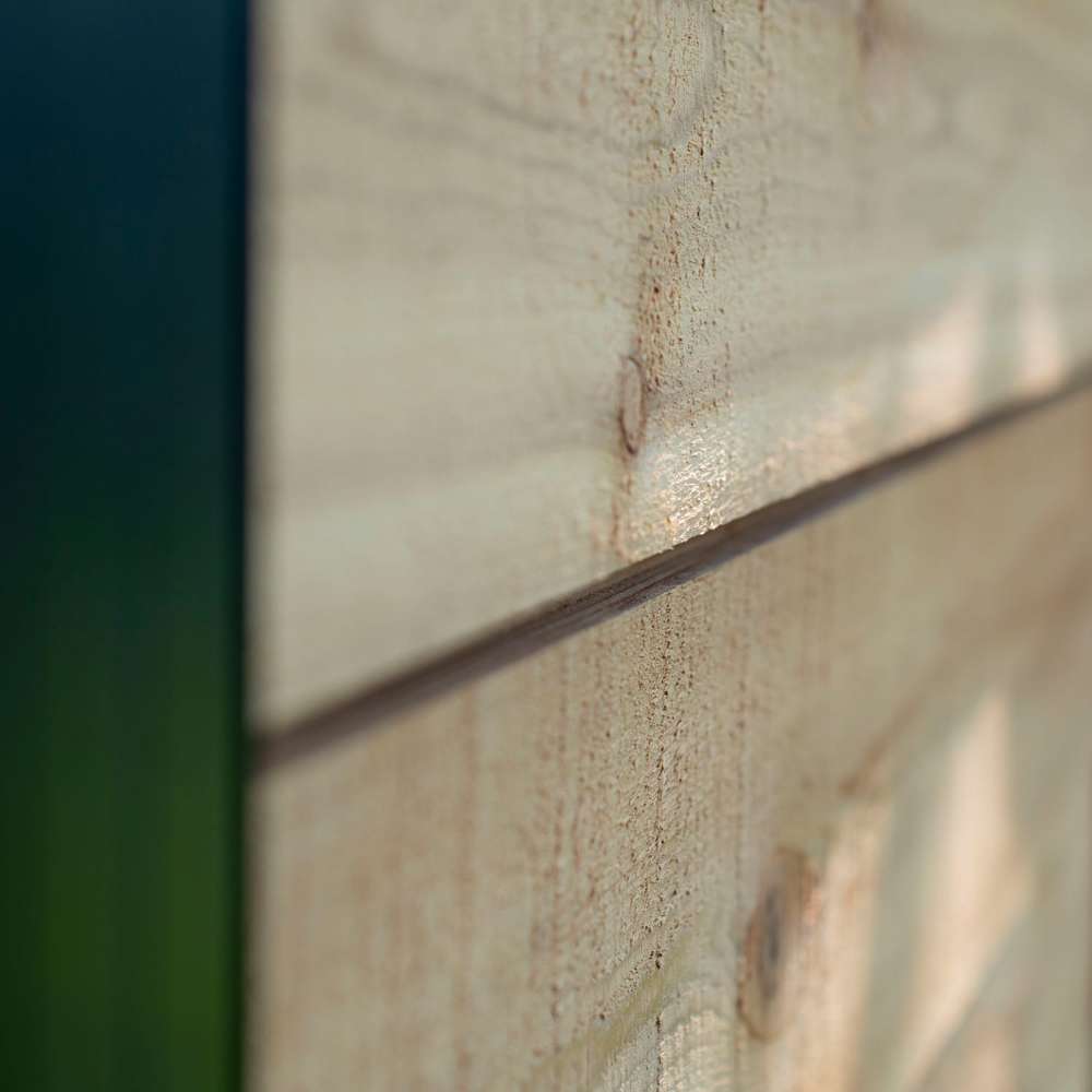 Outdoor Living Today 12×8 Saltbox Studio Outdoor Office is presented in a close-up of horizontal cedar siding highlighting the natural wood texture