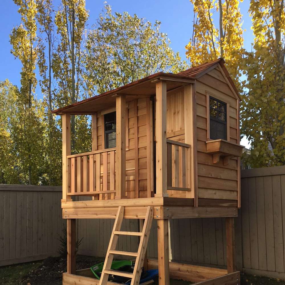 Outdoor Living Today 6x6 Little Cedar Playhouse & Sandbox includes a cedar playhouse with a small porch, ladder, and open play area below