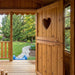 Outdoor Living Today 6x9 Sunflower Playhouse & Sandbox features an interior porch view with a wooden door, heart-shaped cutout, and garden visible outside