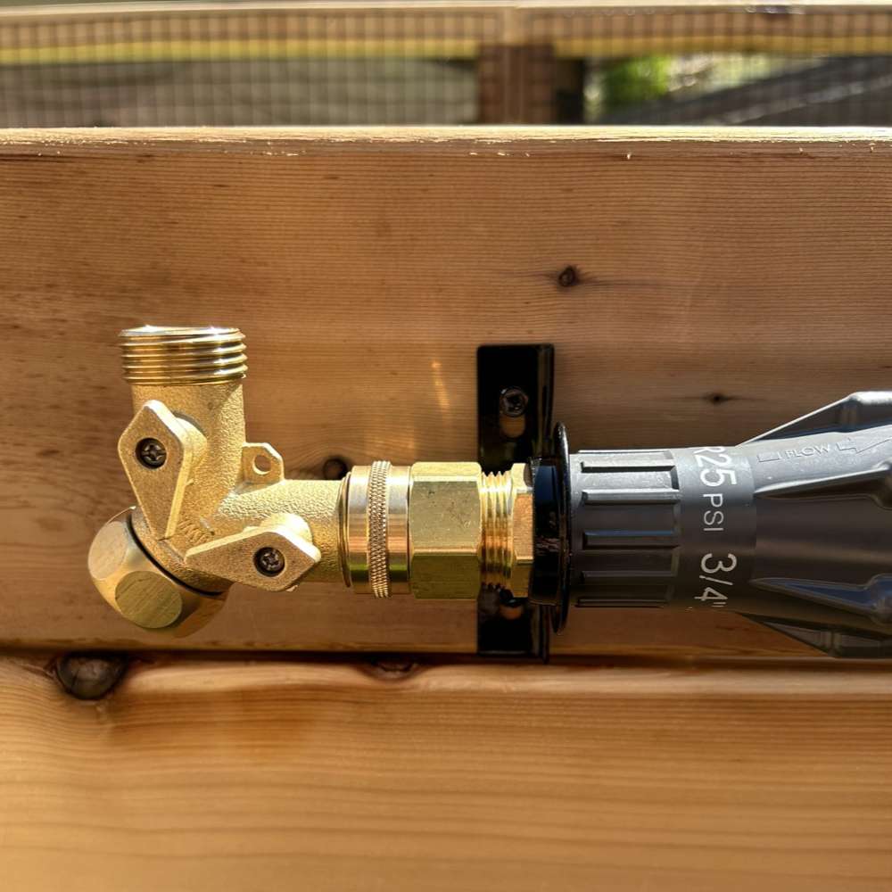 Outdoor Living Today Raised Garden Bed Auto-Watering System pressure regulator and brass fitting attached to a garden bed wall