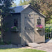 Outdoor Living Today Western Red Cedar Shed Ramp is installed at the entrance of a gray garden shed