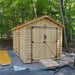 Outdoor Living Today Western Red Cedar Shed Ramp is placed in front of a natural wood shed in a wooded setting