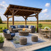 Outdoor seating with fire pit under the Brookside Timber Frame Ridgeview Pavilion on a patio with countryside views