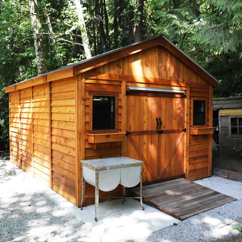 Outdoor Living Today 12×12 Double Door Space Master Storage Shed sits on a gravel lot