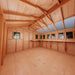 Outdoor Living Today 12×12 Sunshed Garden Shed’s interior features a long side workbench under multiple bright windows and a high wooden ceiling