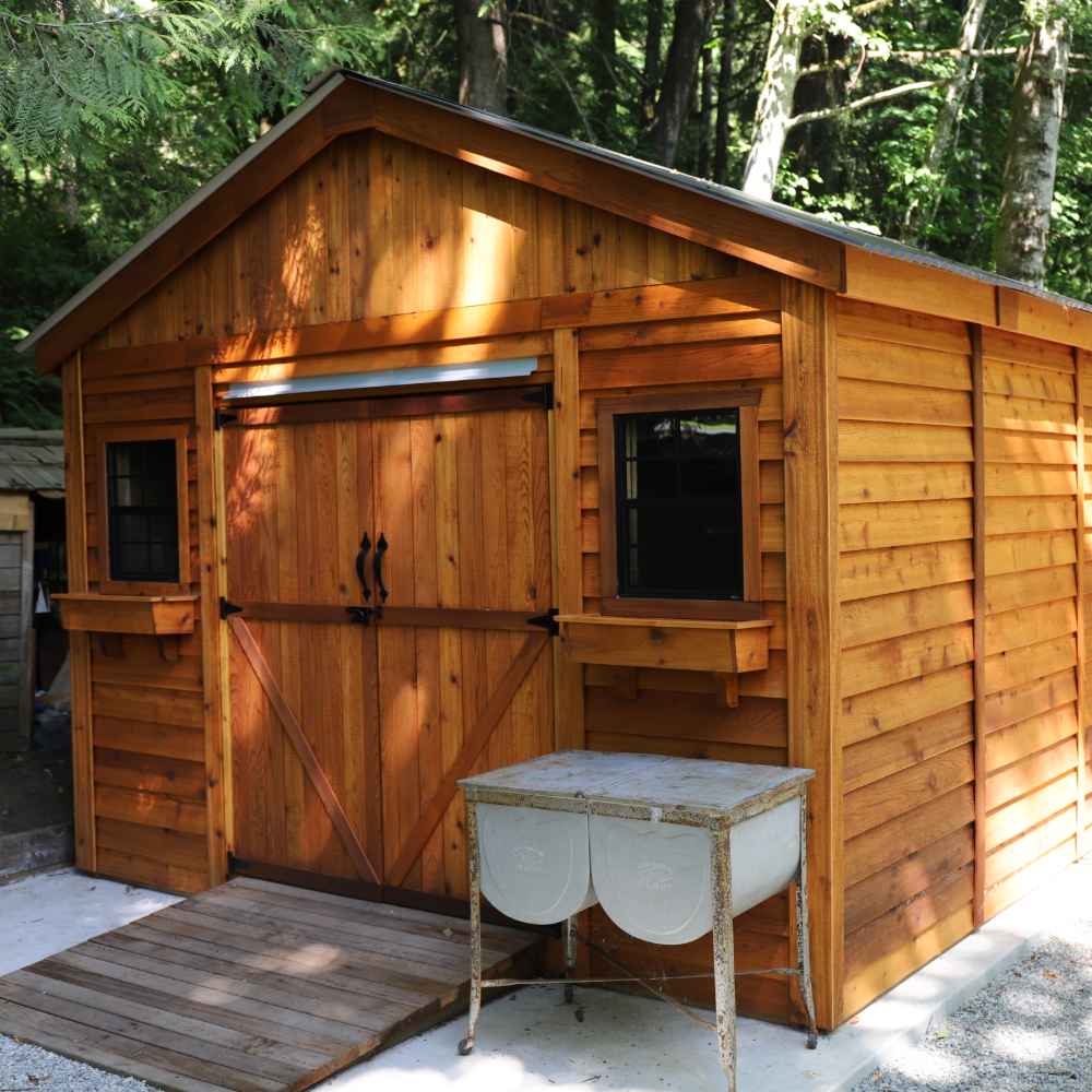 Outdoor Living Today 12×16 Double Door Space Master Storage Shed is a large wooden shed with charming double barn doors and black-trimmed windows