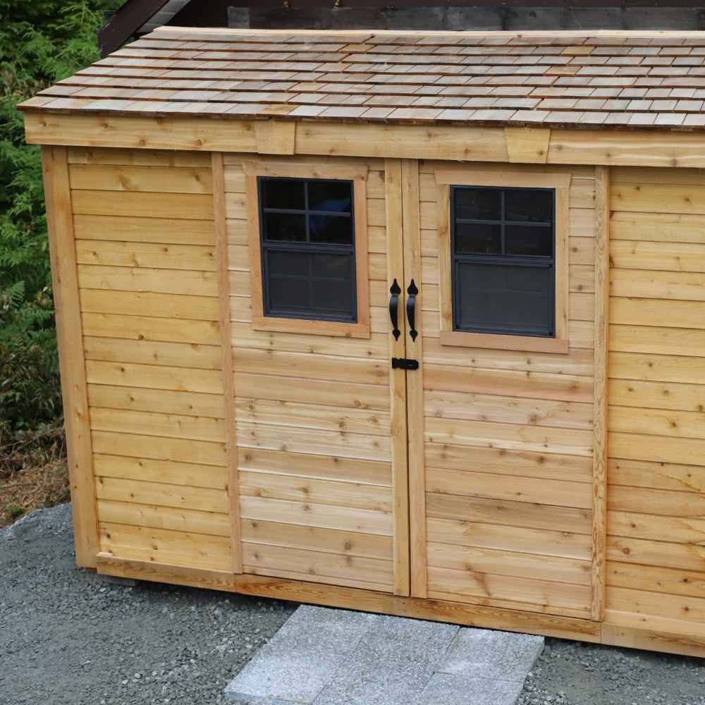 Outdoor Living Today 12×4 with Sliding Doors SpaceSaver Storage Shed features two closed wooden doors with black handles and matching framed windows