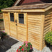 Outdoor Living Today 12×4 with Sliding Doors SpaceSaver Storage Shed sits in a garden surrounded by flowers