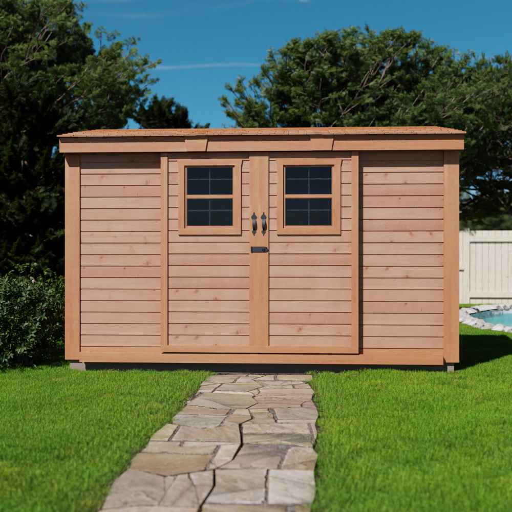 Outdoor Living Today 12×4 with Sliding Doors SpaceSaver Storage Shed stands at the end of a stone pathway in a grassy yard, with its twin windows and doors centered