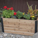 Outdoor Living Today 4×1.5 Urban Raised Garden Bed is filled with bright flowers and plants in a peaceful garden setting