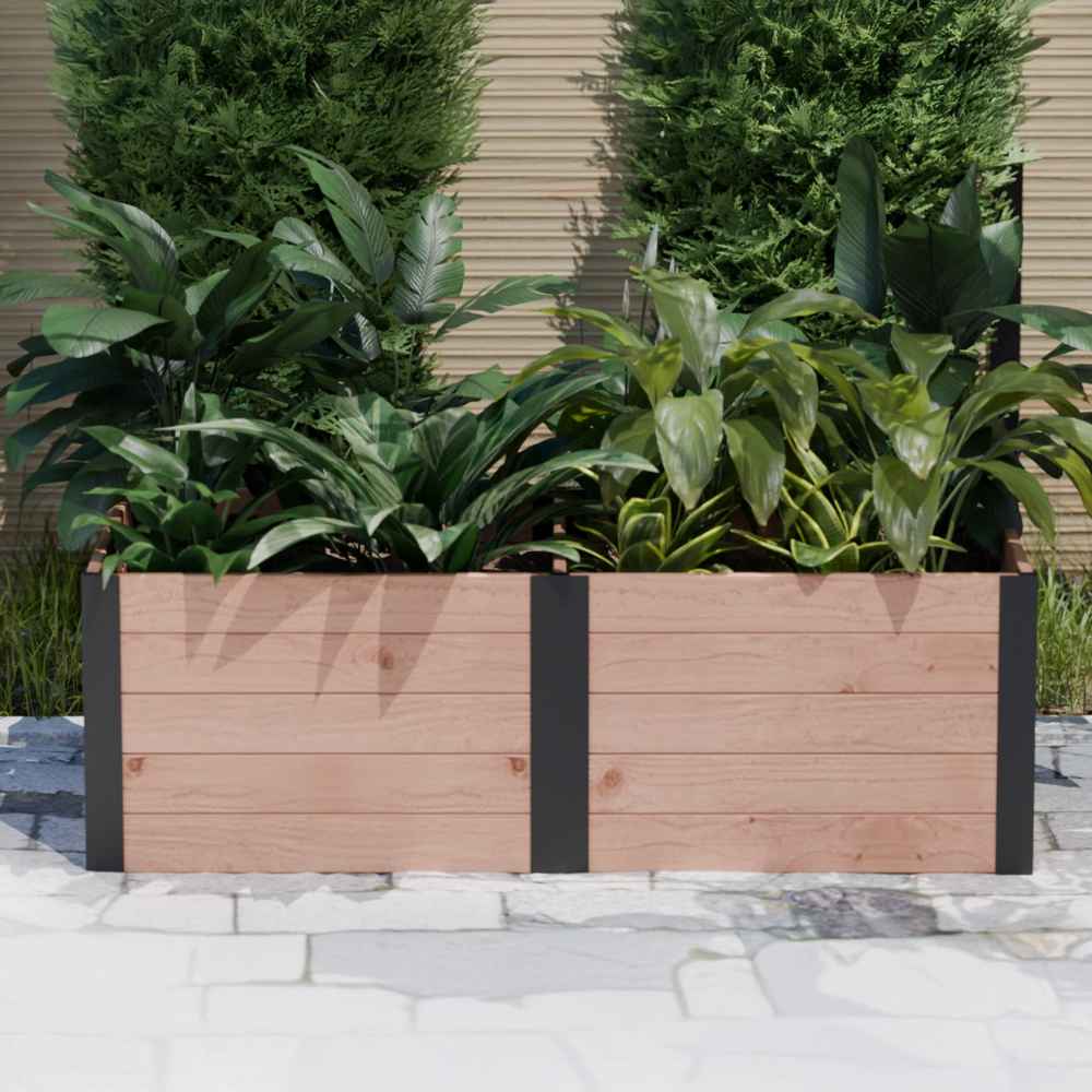 Outdoor Living Today 6×3 Urban Raised Garden Bed is placed on a patio with leafy green plants against a backdrop of tall shrubs