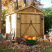 Outdoor Living Today 8×12 Space Master Storage Shed is shown surrounded by autumn leaves, pumpkins, crates, and a wheelbarrow in a cozy fall backyard