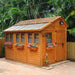 Outdoor Living Today 8×12 Sunshed Garden Shed stands on a brick patio surrounded by tropical plants