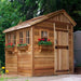 Outdoor Living Today 8×8 Sunshed Garden Shed has flower boxes with bright red blooms and charming wooden windows lining the sunny side