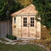Outdoor Living Today 9×9 Penthouse Garden Shed sits tucked in a leafy backyard corner, surrounded by a wooden fence